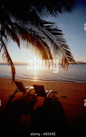 Deux chaises longues de plage vide sur la plage tropicale déserte au coucher du soleil. Le Queensland. L'Australie. Bedarra Island. Banque D'Images