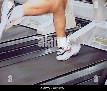 Close-up de jambes en marche sur tapis roulant dans un gymnase Banque D'Images