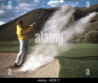 Hits golfeur hors d'un bunker de sable Banque D'Images