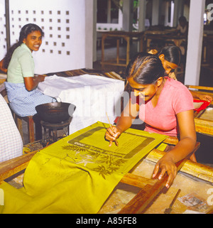 Deux jeunes filles du Sri Lanka était assis sur des bancs appliquer de la cire sur les documents d'une fabrique de batik Sri Lanka Banque D'Images