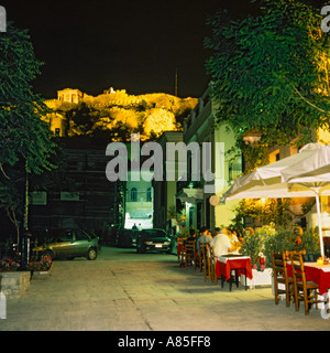 Les gens manger dehors sur une rue calme dans le quartier de Plaka au-dessous de l'Acropole montrant l'Erechtheion nuit à Athènes, Grèce Banque D'Images