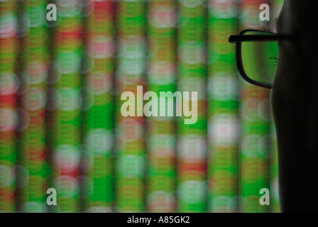 Commerçant à la recherche d'une femelle au grand écran affichage des prix du marché Banque D'Images