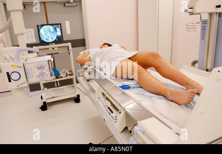 Femme ayant un lavement baryté sur table de Siemens Medical Solutions Axiom SALLE ICONOS R200 de l'unité d'imagerie radioscopique hôpital privé UK Banque D'Images