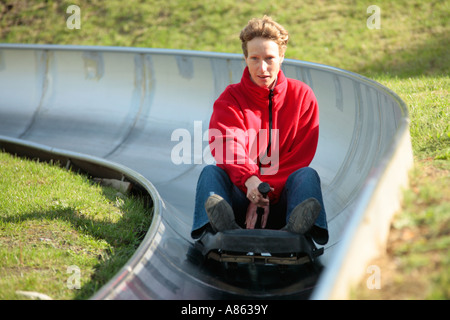Jeune femme sur une luge à sec Banque D'Images