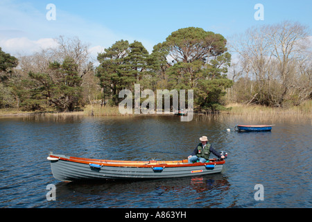 Fisher dans son bateau sur Muckross Lake au Parc National de Killarney, dans le comté de Kerry Banque D'Images