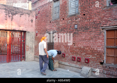 Les touristes à la recherche de traces de trous de balle à Jalianwala Baug , Amritsar , Punjab , Inde Banque D'Images