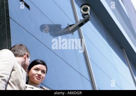 L'homme dit quelque chose dans l'oreille d'une jeune femme Banque D'Images