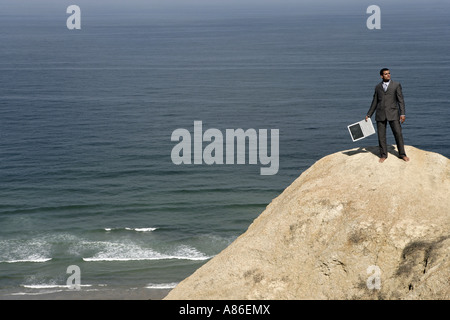 Vue d'un homme debout sur une falaise. Banque D'Images