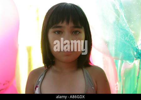 Une petite fille se tient au milieu des ballons. Banque D'Images