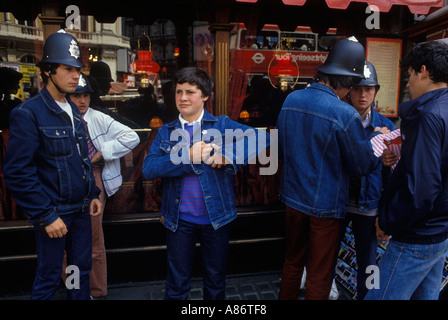 Les adolescents français touristes voyage scolaire à Londres portant des chapeaux policier comme souvenirs shop des années 1990 au Royaume-Uni. HOMER SYKES Banque D'Images