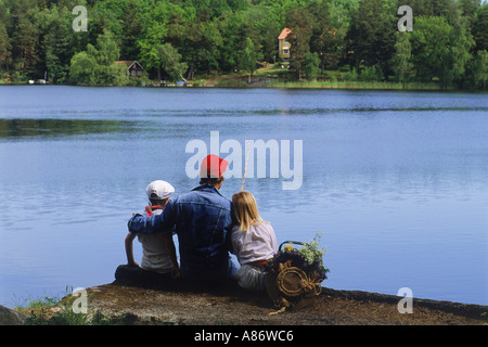 Papa et les enfants sur la pêche au bord du lac en été, pique-nique en Suède Banque D'Images
