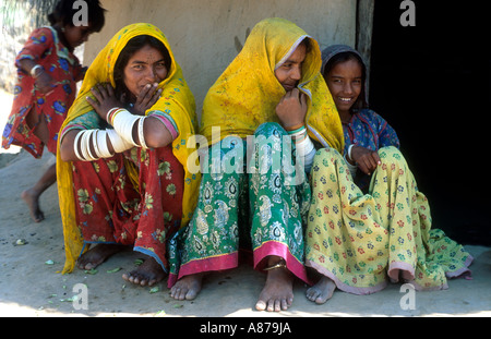 Portrait de paysage de trois sœurs dans une robe traditionnelle colorée assise dans un village rural pauvre à Thar Parkar, au Pakistan Banque D'Images