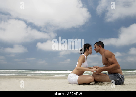 Vue d'un couple assis sur une plage. Banque D'Images