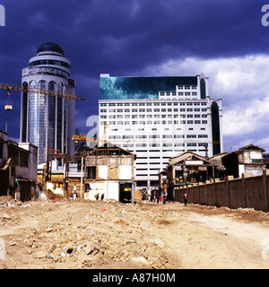 De nouveaux bâtiments d'affaires moderne,se lever sur les ruines de démoli des maisons traditionnelles sous un ciel d'orage,Kunming, Chine Banque D'Images