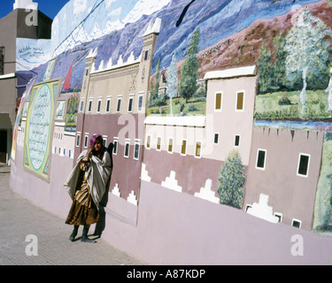 Jeune fille local appuyé contre un grand mur peint peinture,Maroc Banque D'Images