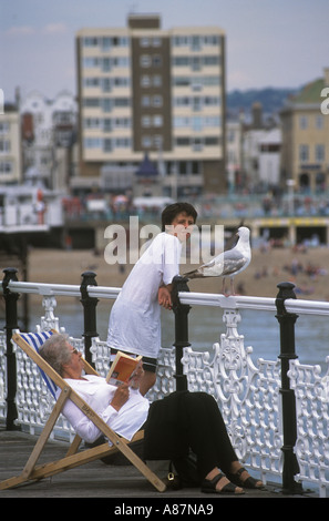 Brighton Seafront un jeune garçon a une conversation avec un goéland argenté sur le Palace Pier East Sussex, Angleterre 20001 2000s UK HOMER SYKES Banque D'Images