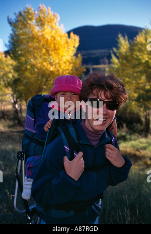 Portrait d'une mère portant son bébé fille sur son dos lors d'une randonnée dans les Montagnes Rocheuses à l'automne Banque D'Images