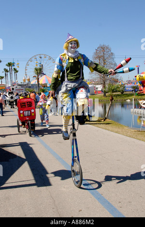 Circonscription de clown sur un monocycle participe à une parade à la foire de l'État de Floride à Tampa Florida FL Banque D'Images