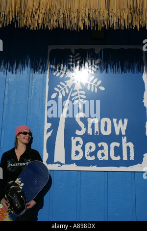 Woman in pink hat holding un snowboard Banque D'Images