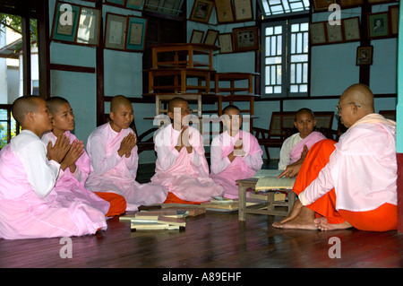 Les novices dans l'école avec une religieuse en tant qu'enseignant sur le parquet de Zayyartheingi antiq Birmanie Mandalay Sagaing Banque D'Images