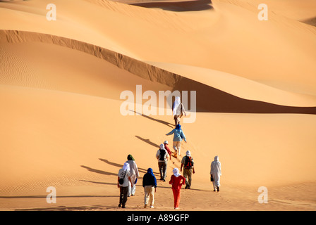 Randonnée à travers les touristes sanddunes dans le désert libyen Mandara Banque D'Images