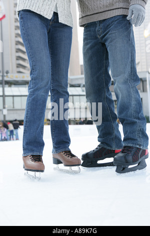 Homme et une femme portant des jeans et des patins à glace Banque D'Images