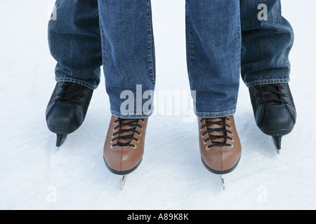 Deux personnes portant des jeans sur patins à glace Banque D'Images