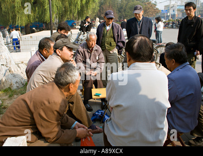 Chine Pékin une foule de Chinois se réunit pour regarder un jeu de cartes se joue sur le trottoir par Qianhai Lake dans le dos Lacs Banque D'Images