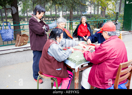 BEIJING CHINE Personnes âgées femmes chinoises et un homme jouer mahjong un jeu chinois d'adresse et de chance en utilisant 600x600 Banque D'Images