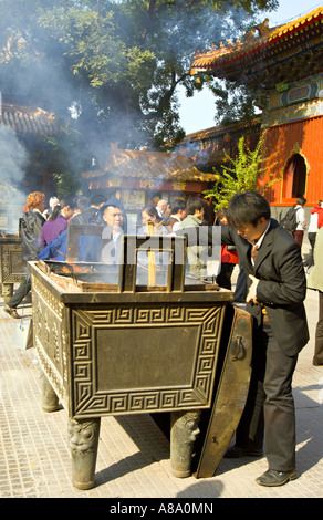 Les bouddhistes chinois CHINE Pékin y compris un jeune homme dans un costume brûlent de l'encens et prier Banque D'Images