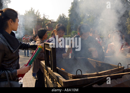 Chine Pékin jeunes Chinois bouddhistes brûlent de l'encens et prier à l'extérieur du palais de la paix et l'harmonie Yonghegong Lama Temple Banque D'Images