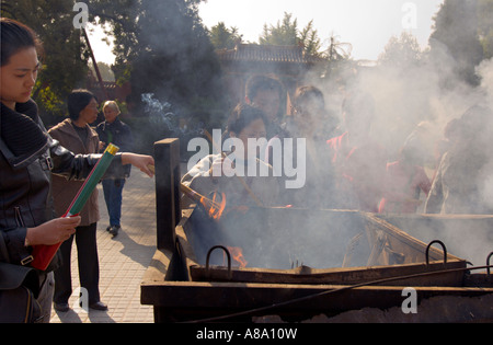 Chine Pékin jeunes Chinois bouddhistes brûlent de l'encens et prier à l'extérieur du palais de la paix et l'harmonie Yonghegong Lama Temple Banque D'Images