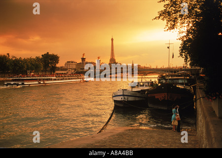 Près de deux péniches sur la Seine à Paris au coucher du soleil avec la Tour Eiffel Banque D'Images