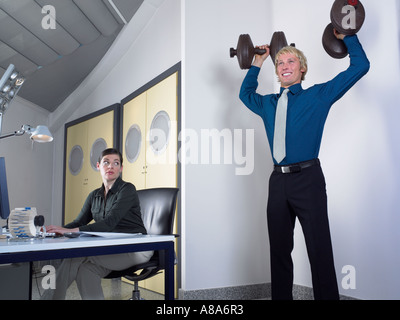 Office worker lifting weights Banque D'Images