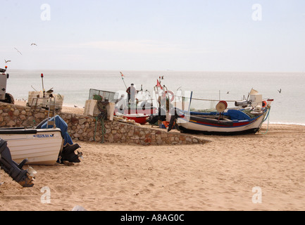 Les bateaux de pêche et les pêcheurs sur la plage de Salema, Portugal Banque D'Images