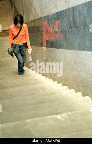 Jeune femme qui monte les marches du métro pour les rues de la ville au-dessus Banque D'Images