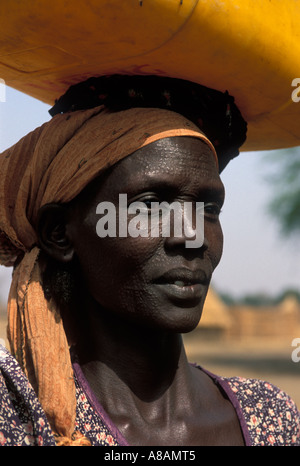 Femme avec des cicatrices du visage traditionnels à la collecte de l'eau de la rivière Baro, Gambella, Ethiopie Banque D'Images