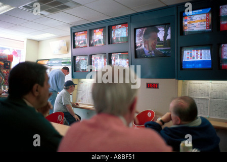 Les gens qui suivent les événements en direct sur les écrans de télévision dans un bureau de Paris London UK Banque D'Images