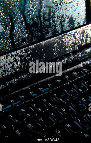 Ordinateur portable avec gouttelettes d'eau sur le clavier et l'écran Banque D'Images