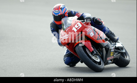 Une MOTO RIDER OBTIENT SON GENOU VERS LE BAS SUR LA PISTE À LA JOURNÉE CIRCUIT à Donington Park dans le Leicestershire, UK. Banque D'Images