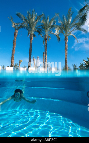 Une femme âgée de 40 ans nage sous l'eau dans la piscine de l'hôtel Four Seasons Sharm el Sheikh Mer Rouge Sinaï Égypte Becky Hallsmith Banque D'Images