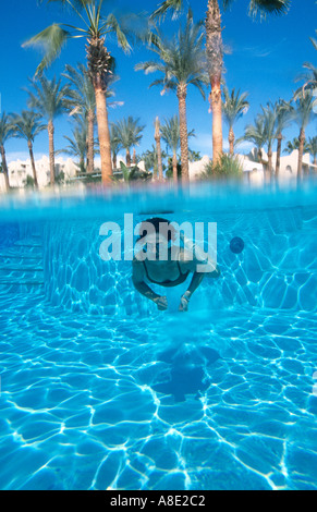 Une femme âgée de 40 ans nage sous l'eau dans la piscine de l'hôtel Four Seasons Sharm el Sheikh Mer Rouge Sinaï Égypte Becky Hallsmith Banque D'Images