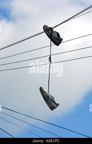 Shoes hanging from 'Téléphone' fil Banque D'Images