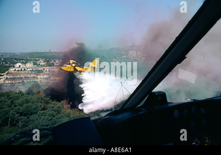 Vue aérienne d'un avion Bombardier d'eau Canadair feu arrosant à l'eau sur une forêt près de la ville de Marseille, Provence, France, Europe, Banque D'Images