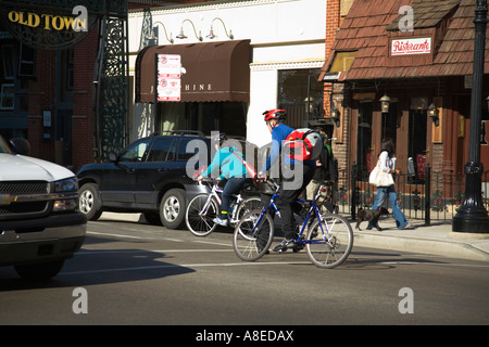 CHICAGO Illinois Deux cyclistes dans la piste cyclable sur la rue Puits des piétons sur trottoir dans le quartier de la Vieille Ville Banque D'Images