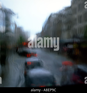 Vue sur une file de taxis noirs sur Oxford Street, face à une fenêtre par temps pluvieux dans la circulation Londres Angleterre Royaume-Uni Grande-Bretagne KATHY DEWITT Banque D'Images