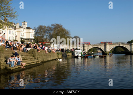 Les gens se détendre sur les bords de la Tamise à côté de Richmond Bridge, London, England, UK Banque D'Images