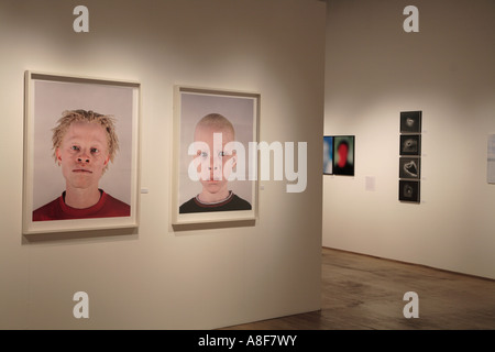 Photos avec visages d'hommes et de femmes exposées dans une galerie photo Banque D'Images