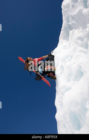 Les femmes avec l'escalade de glace sur sac à dos Snowboard Banque D'Images