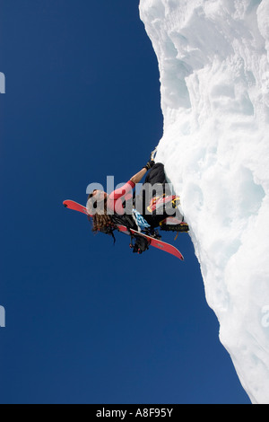 Les femmes avec l'escalade de glace sur sac à dos snowboard Banque D'Images